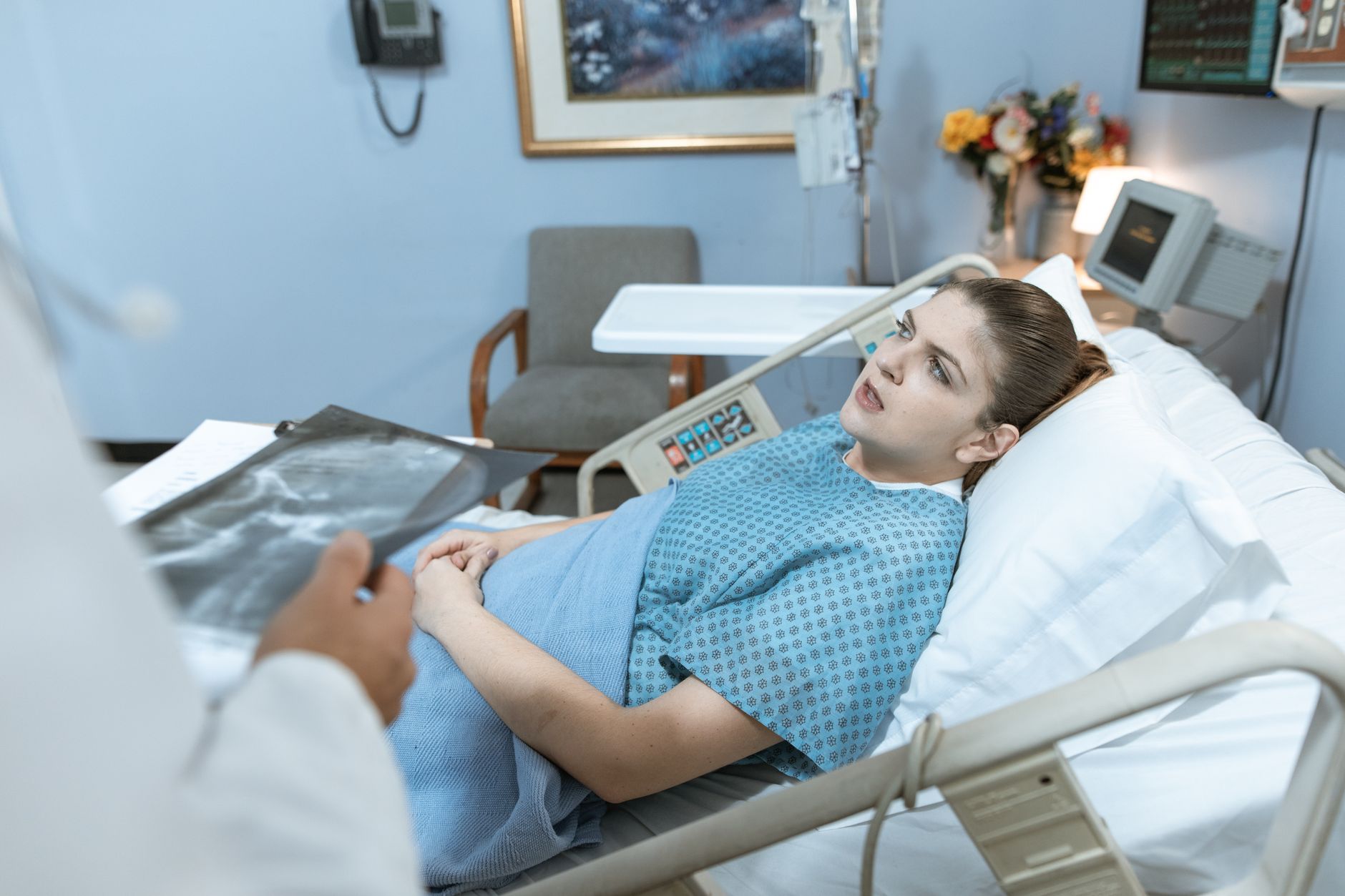 Caucasian woman in hospital bed receiving care from healthcare professional. — 4 People Medical Cannabis Patients Should Talk
