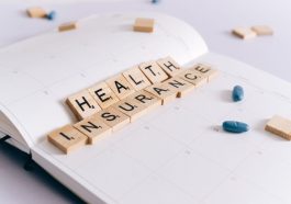 Scrabble tiles spelling 'Health Insurance' on a calendar with pills. — Athem Blue Mix Offering Two New Medical Health Insuran