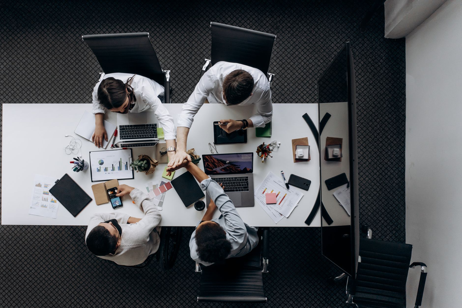 High angle view of colleagues collaborating around a conference table in a modern office setting. — Beyond Muscle Mass: Stero