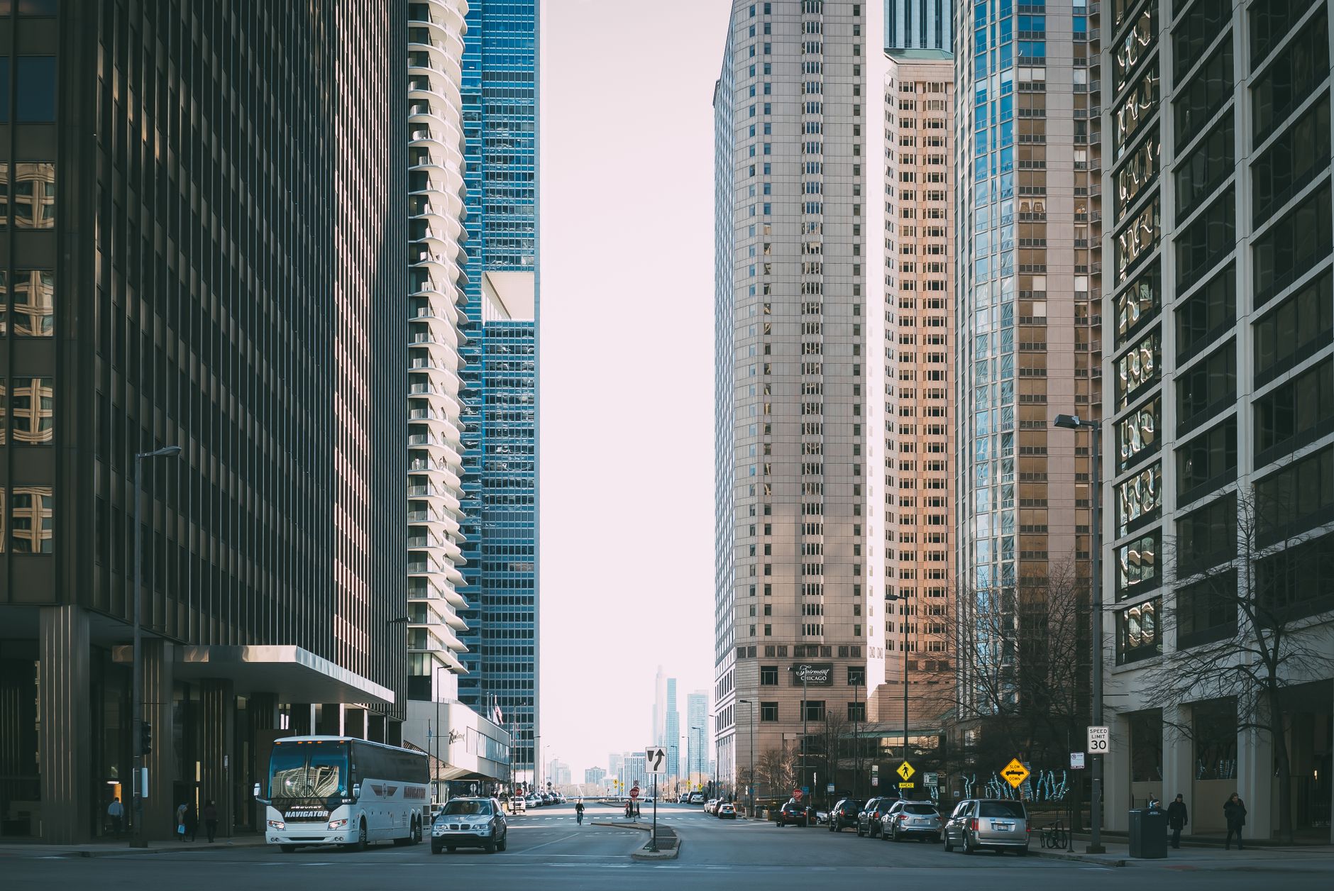 Vibrant city street scene with tall skyscrapers and city life full of cars and pedestrians. — Buy A House The Proficient Way: