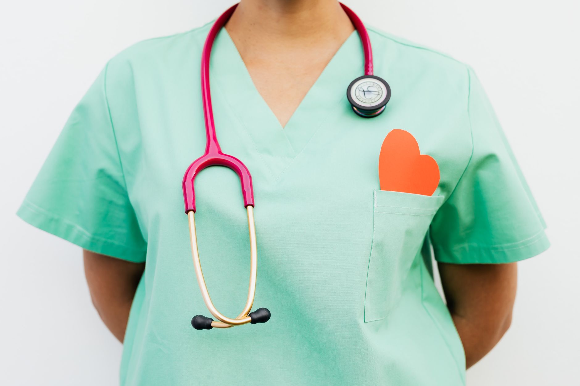 Close-up of a medical professional with a stethoscope and a paper heart cutout on a green uniform pocket. — Choosing a good o