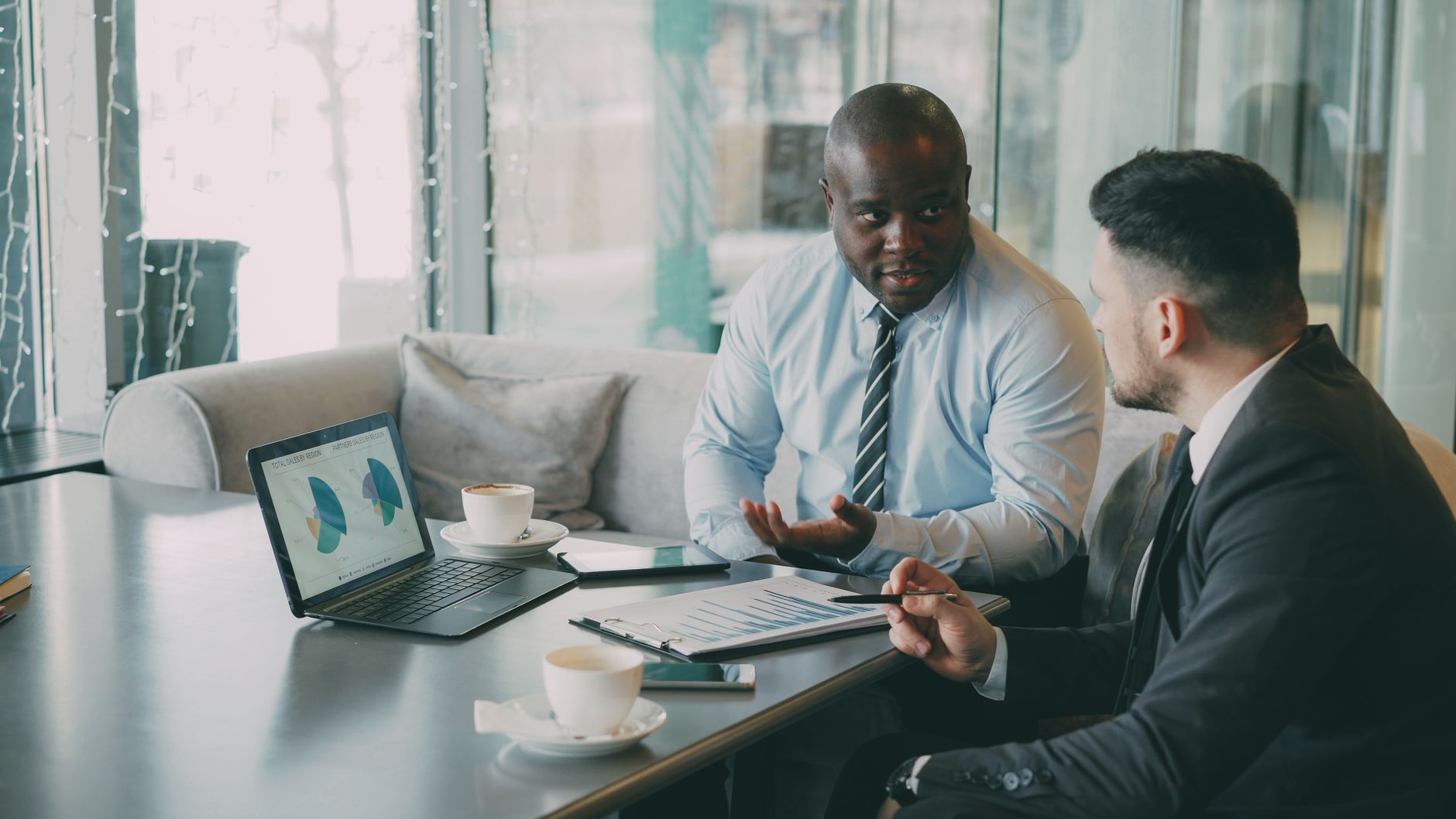 Two business professionals engaged in discussion over laptops and documents. — CVG Cares: A Beacon of Hope for Underprivilege