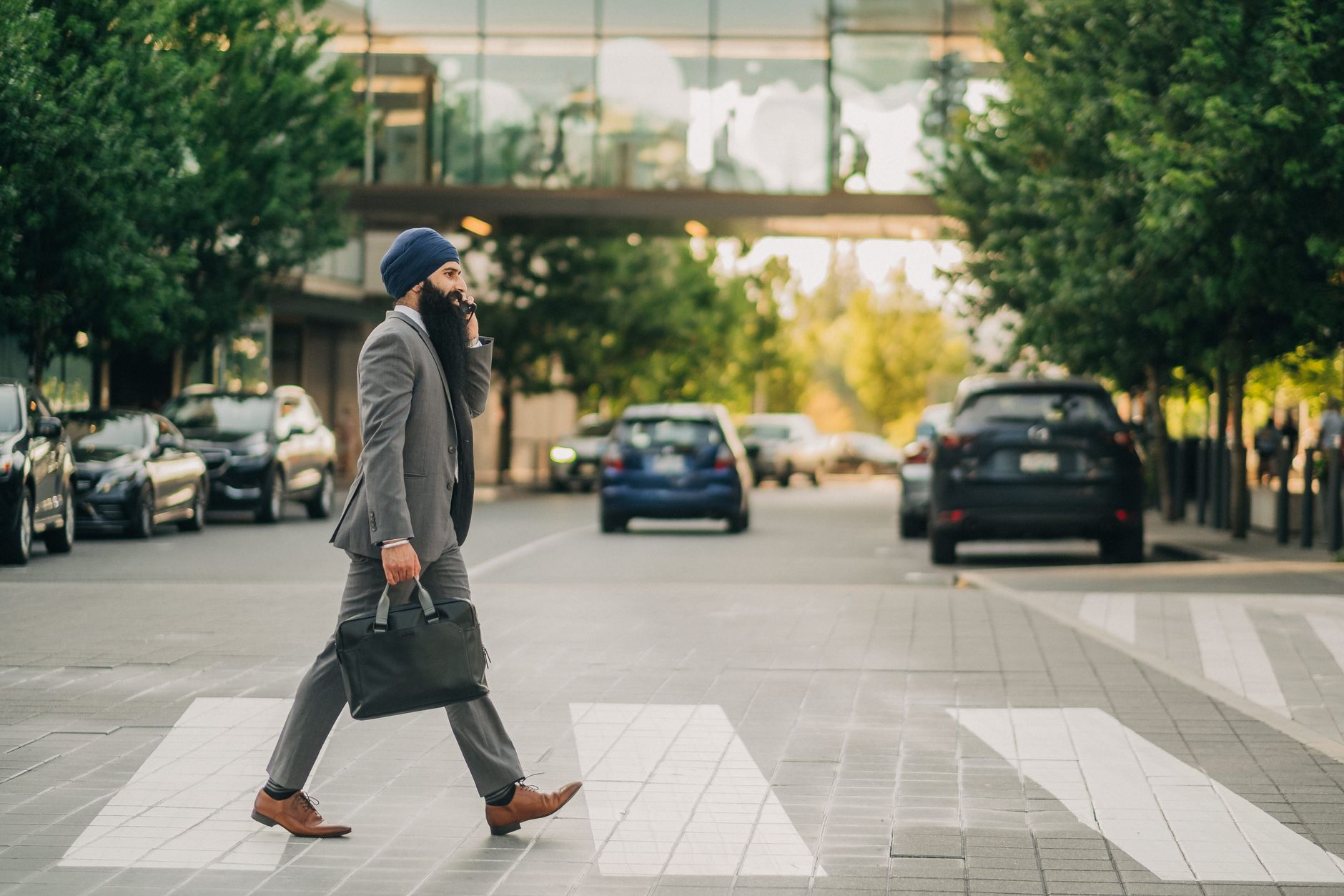 Sikh businessman with a turban crossing a city street on a zebra crossing, carrying a briefcase. — DaVinci IQC: Smart Vaping