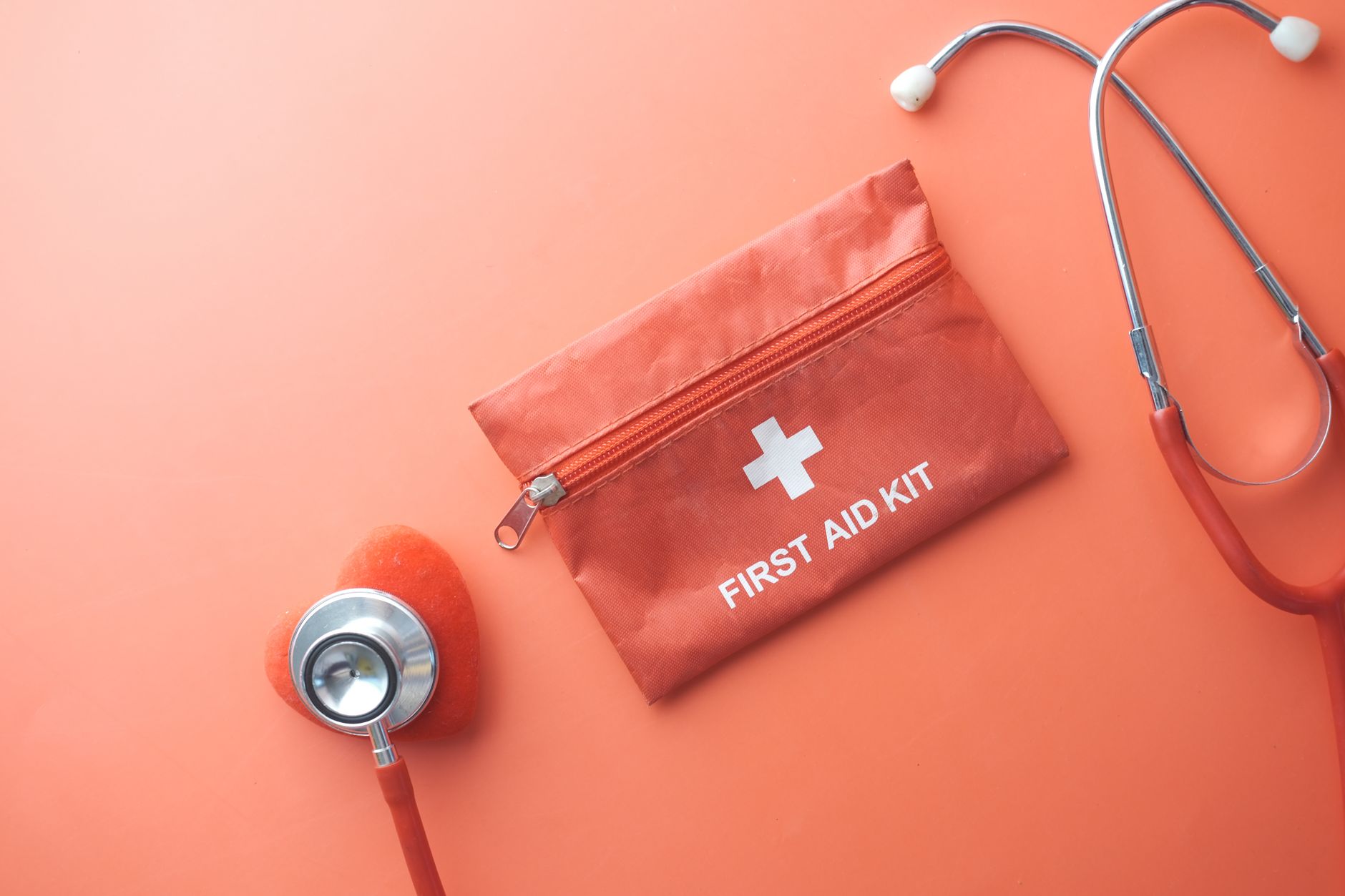 Medical tools including a stethoscope and first aid kit on a pink surface, perfect for healthcare themes. — Dental Insurance
