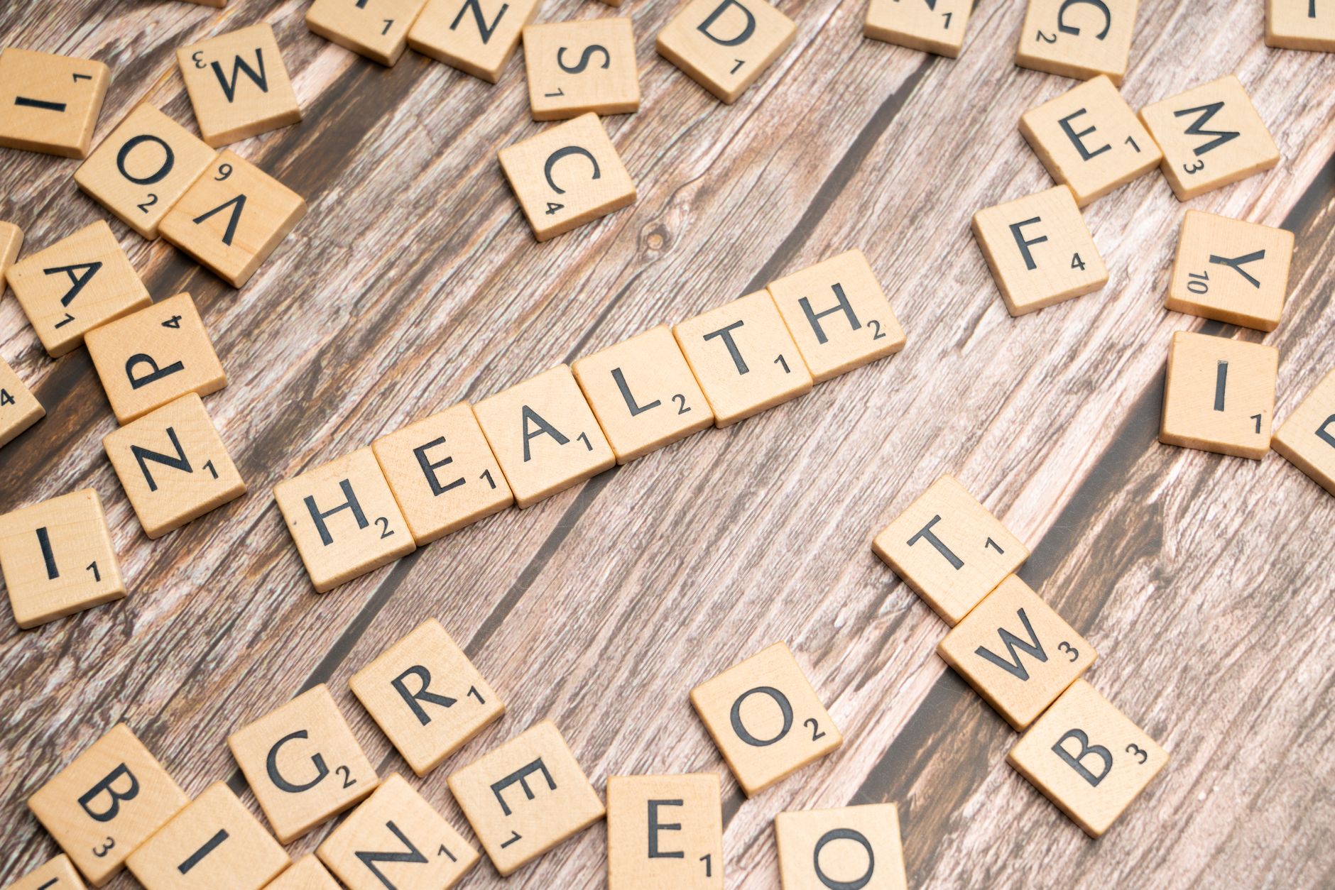 Scrabble tiles spelling 'HEALTH' on wooden surface, symbolizing wellness. — Diabetes Linked to Heart Disease Risk in Older Ad