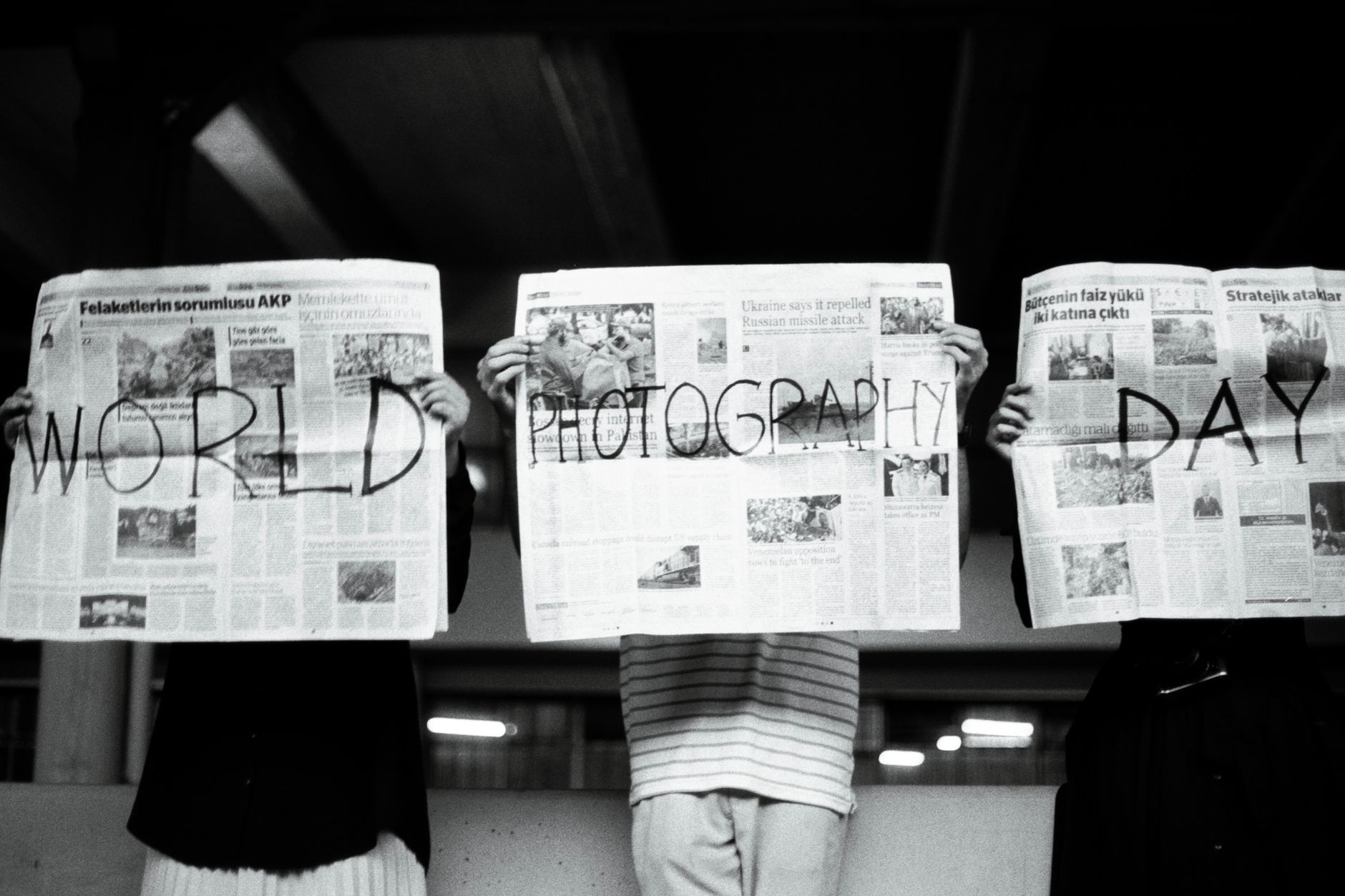 Three people hold newspapers with 'World Photography Day' text, artistic vibe. — Diindolylmethane: The Natural Way to Balance