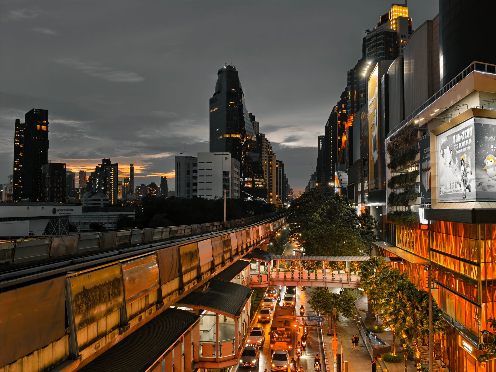 Cityscape at twilight showing busy traffic, skyscrapers, and an elevated train line in an urban setting. — Discover New Hope