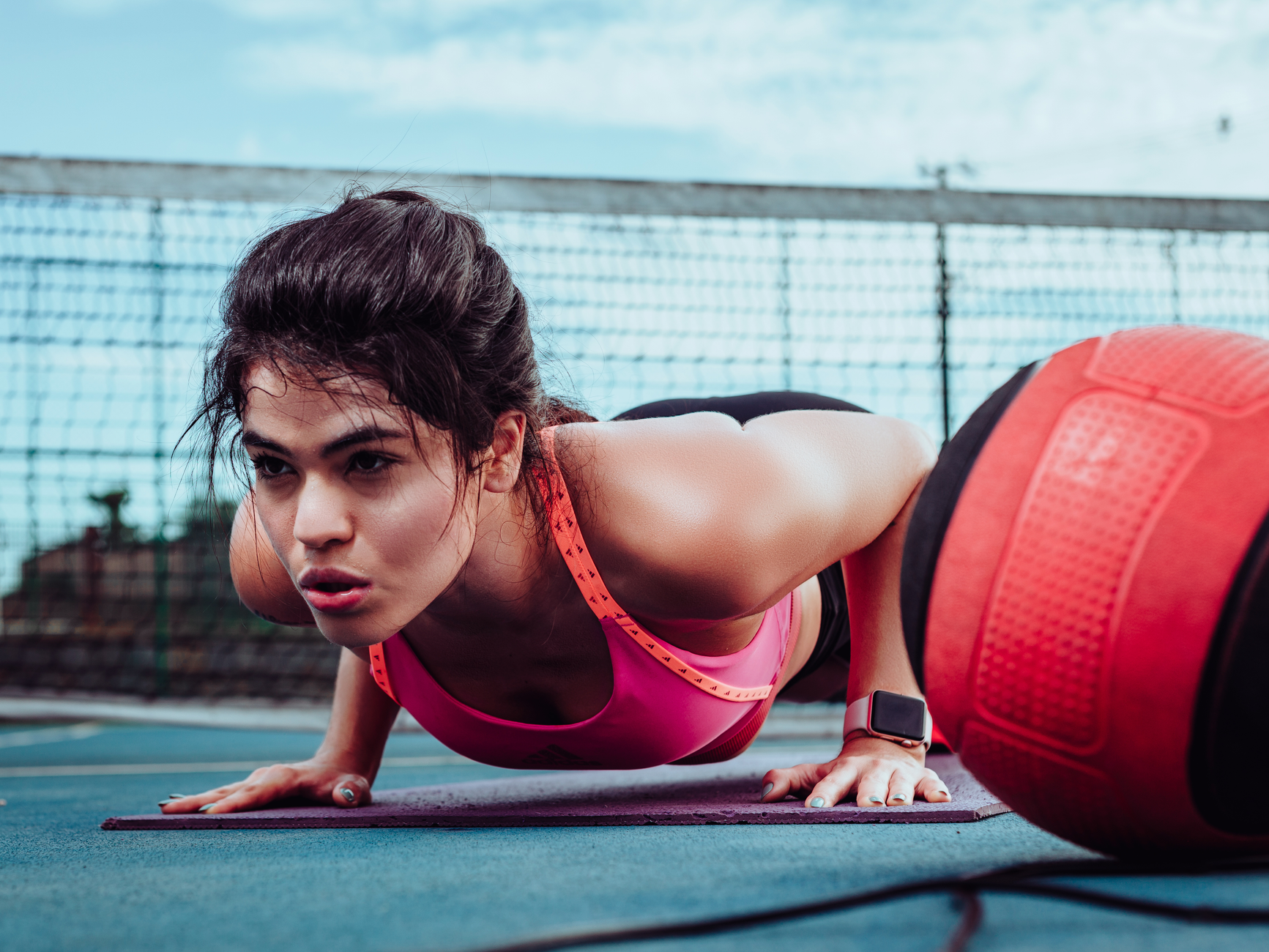 Woman doing push-ups on a sports court in Ji-Paraná, Brasil, focusing on fitness outdoors. — Discover the Applications of the