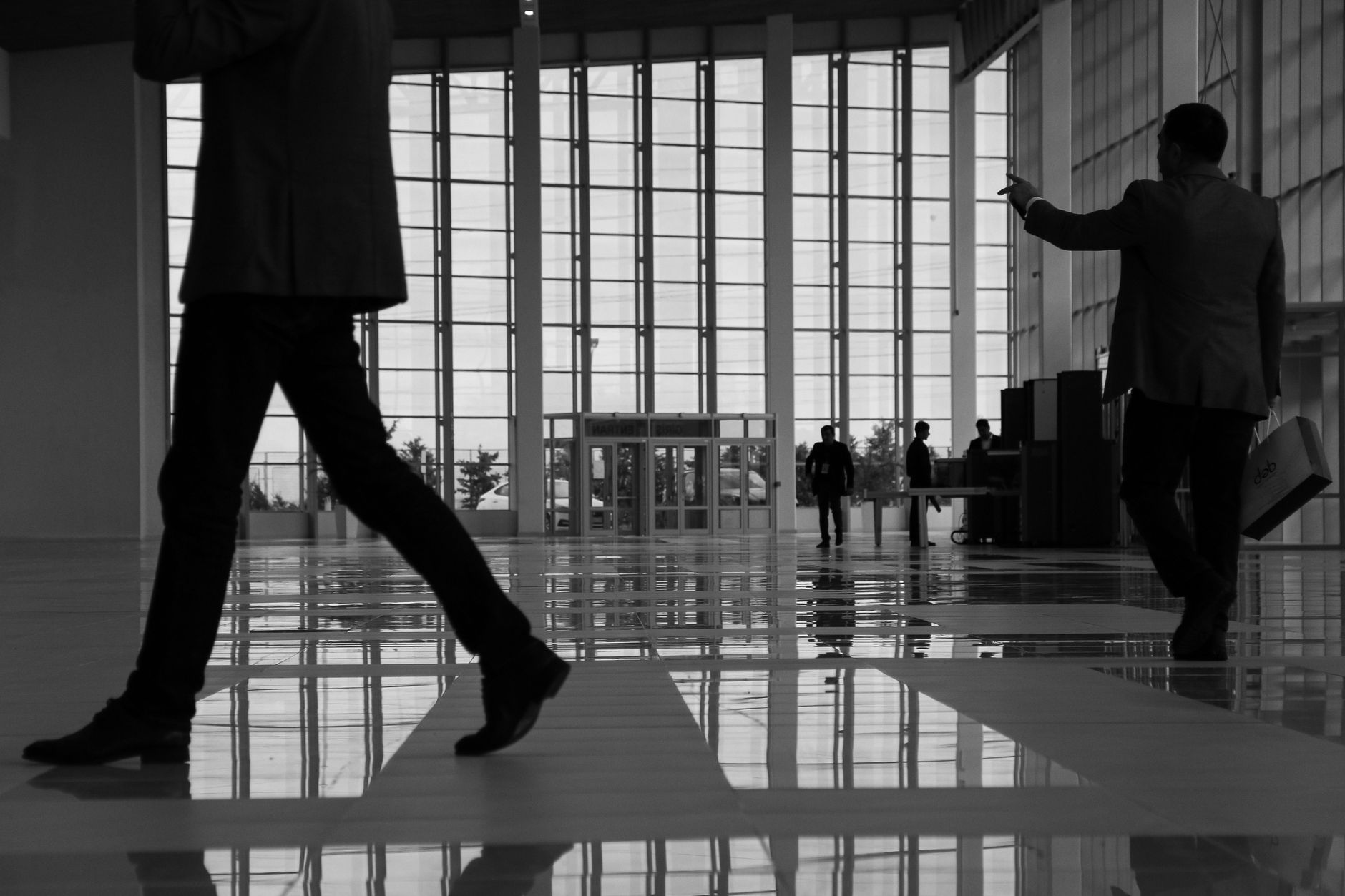 Business professionals walk through a modern, glass-paneled indoor space. — Easy and Inexpensive Ways to Remove Wrinkles with