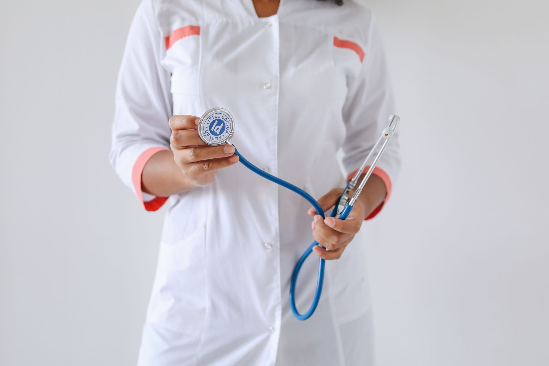 Close-up of a female doctor holding a blue stethoscope, emphasizing healthcare and professionalism. — Erotic Massage Techniqu