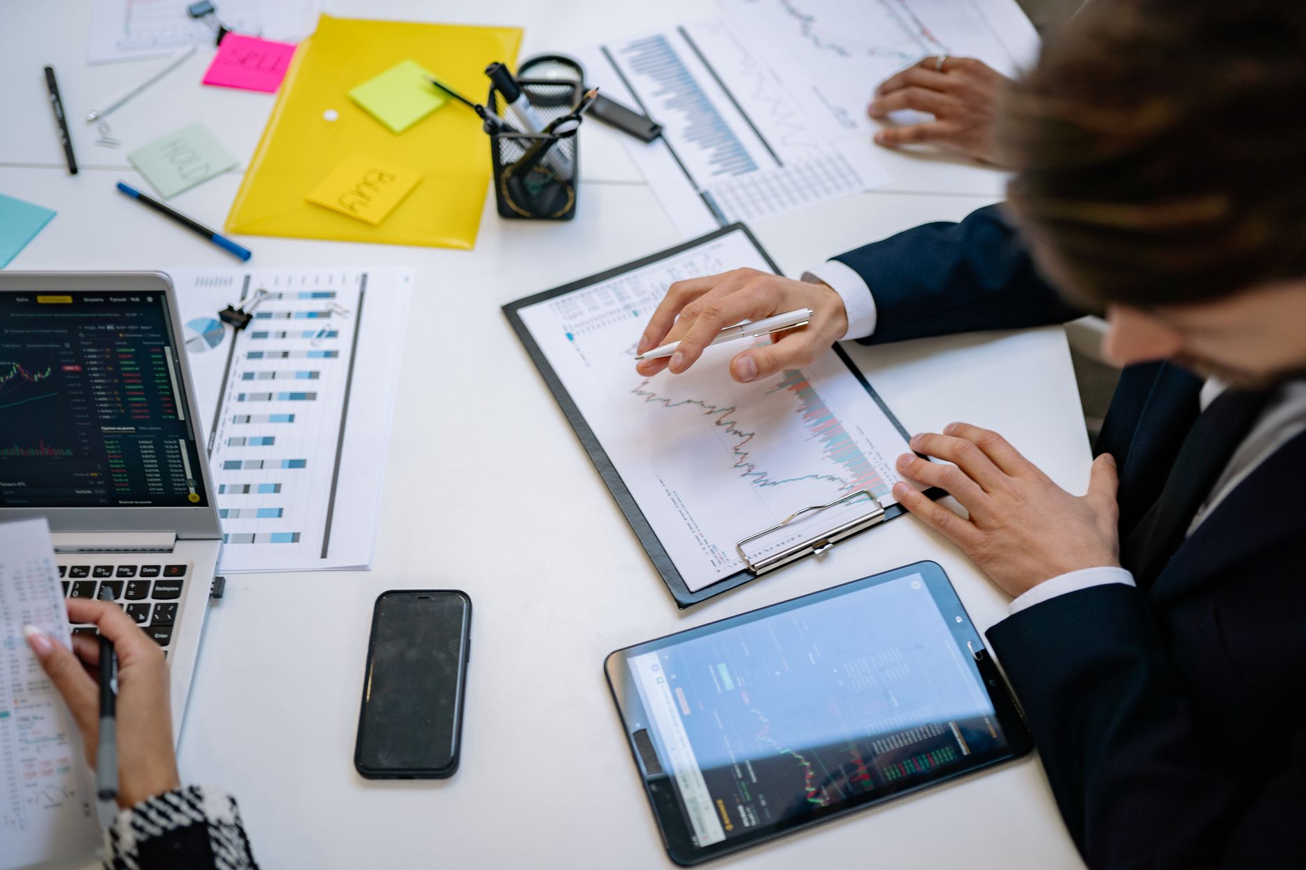 Team reviewing financial charts and digital data on tablets in an office setting. — Expert Advice on Buying Anavar: A User's