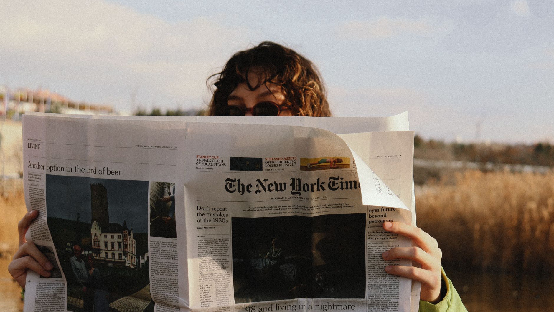 A person reads The New York Times outside on a sunny day, capturing a moment of leisure. — Exploring the Cognitive Enhancemen