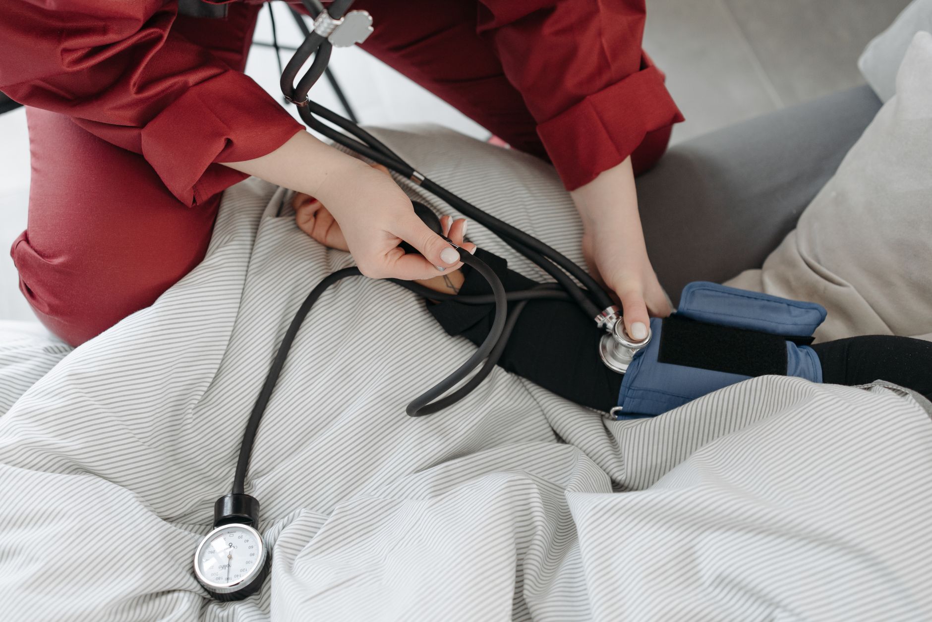 A medical professional checking a patient's blood pressure using a sphygmomanometer in a cozy setting. — Factors To Look For