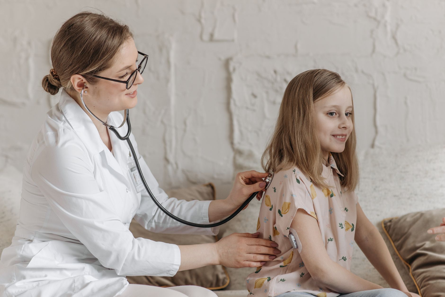 A doctor uses a stethoscope during a check-up with a young girl in a medical setting. — Get the emergency dentist you need
