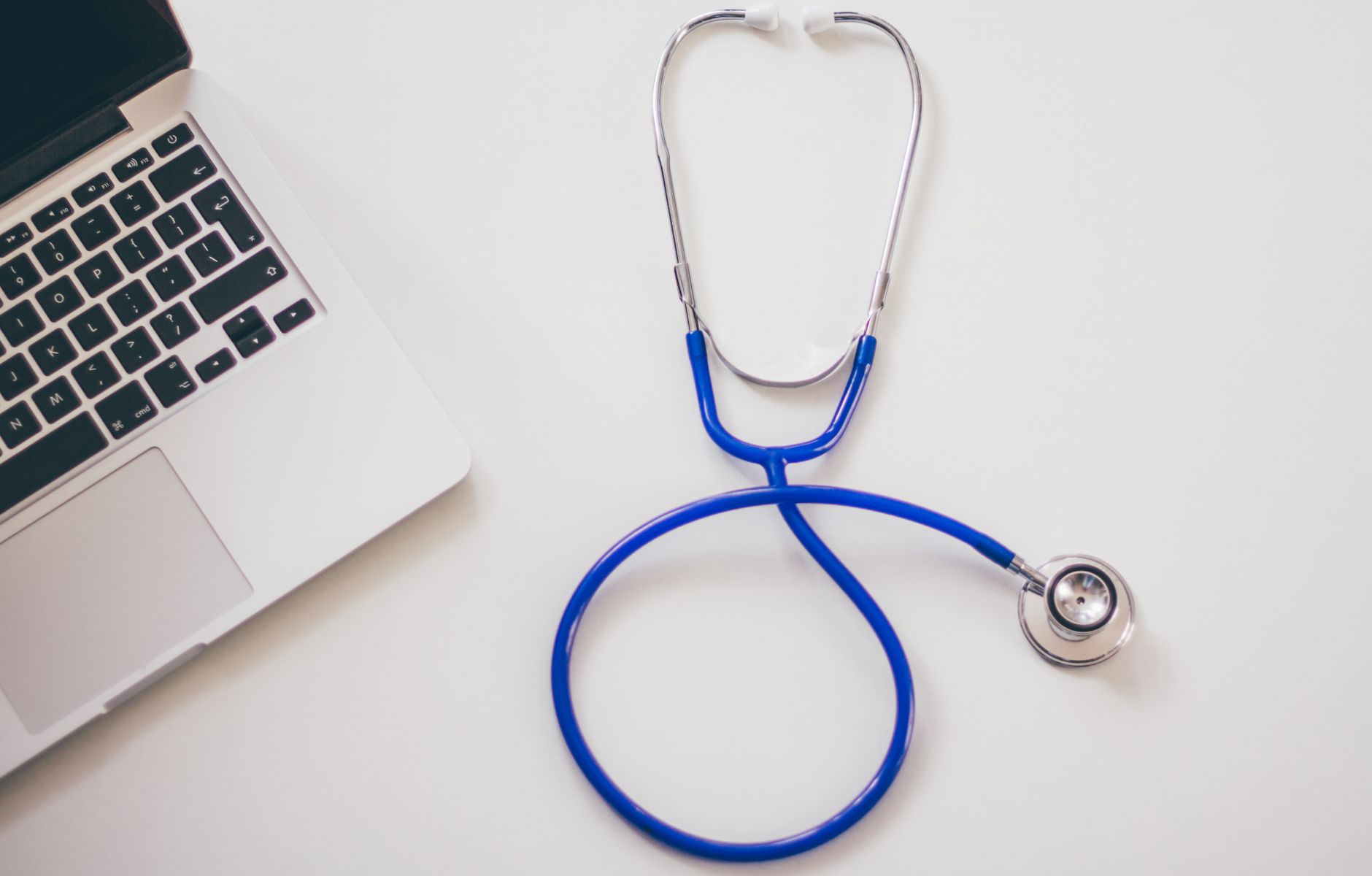 Medical stethoscope and laptop on a white desk, symbolizing digital health solutions. — Guide on Vype iPod