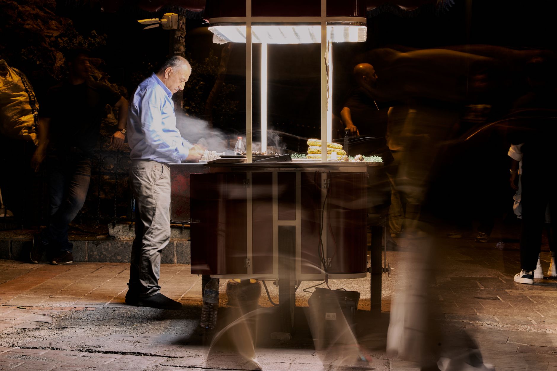 Street vendor cooking food at night with blurred people passing by. — High Risk Payment Processing That Keeps Transactions Fl