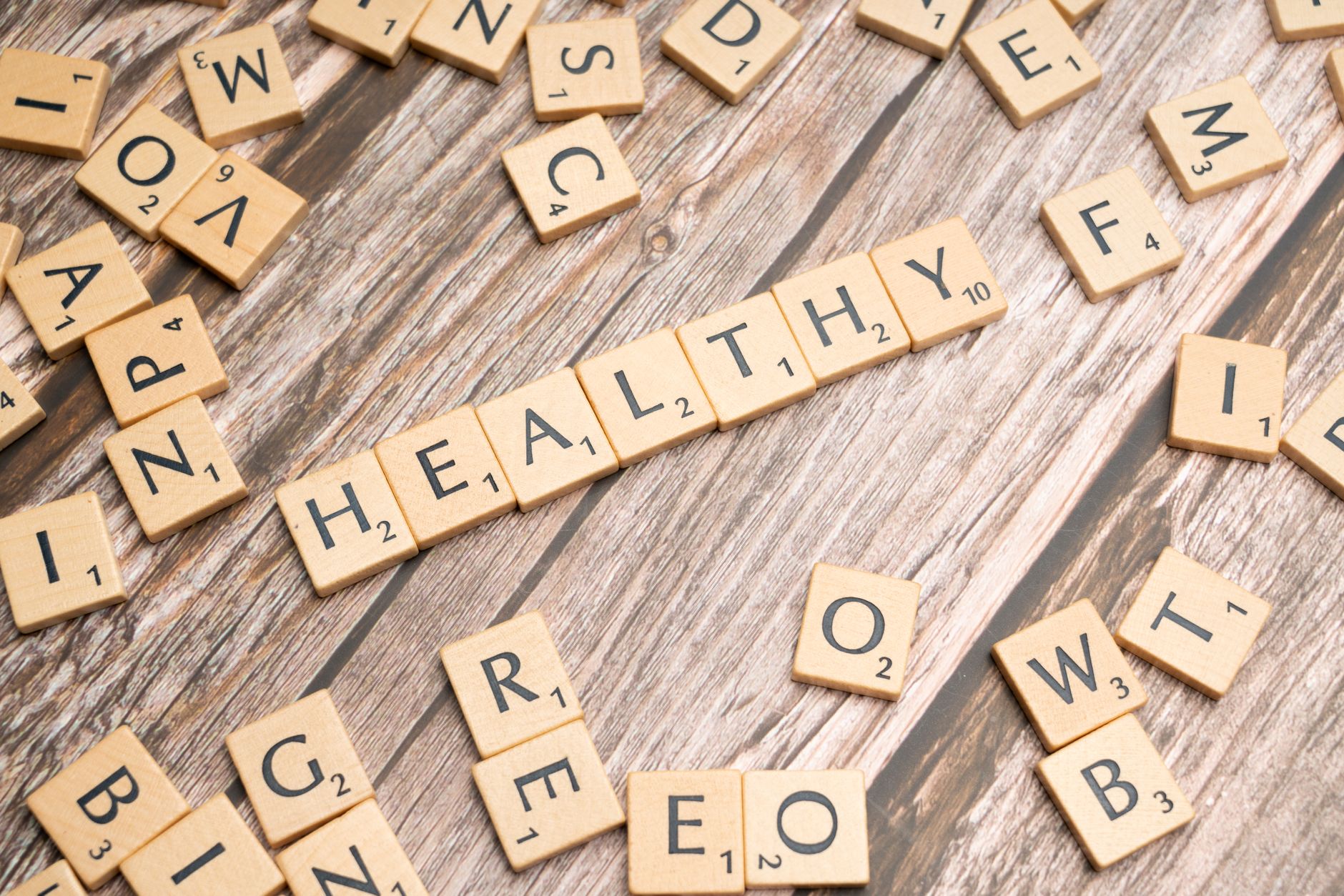 Wooden letter tiles arranged on a wooden surface spelling out 'healthy', symbolizing wellness. — How DBT Can Help with Differ