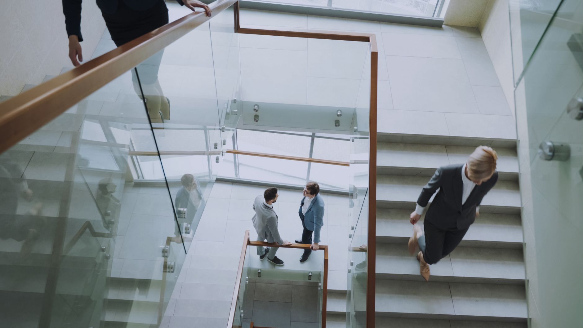Aerial view of professionals conversing in a glass staircase in a modern office. — How to Access a Free, Printable Doctor's N