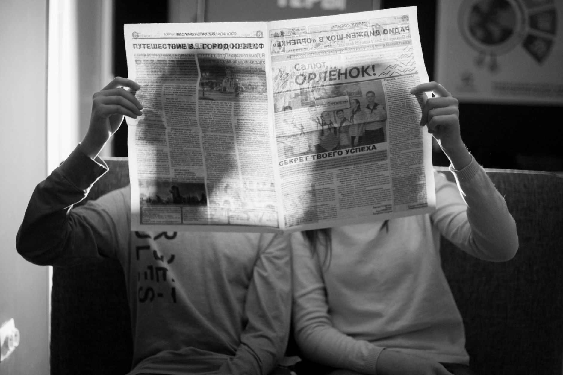 A couple sitting indoors reading a newspaper in a black and white photograph. — Insider Communication Playbook for Floridadat