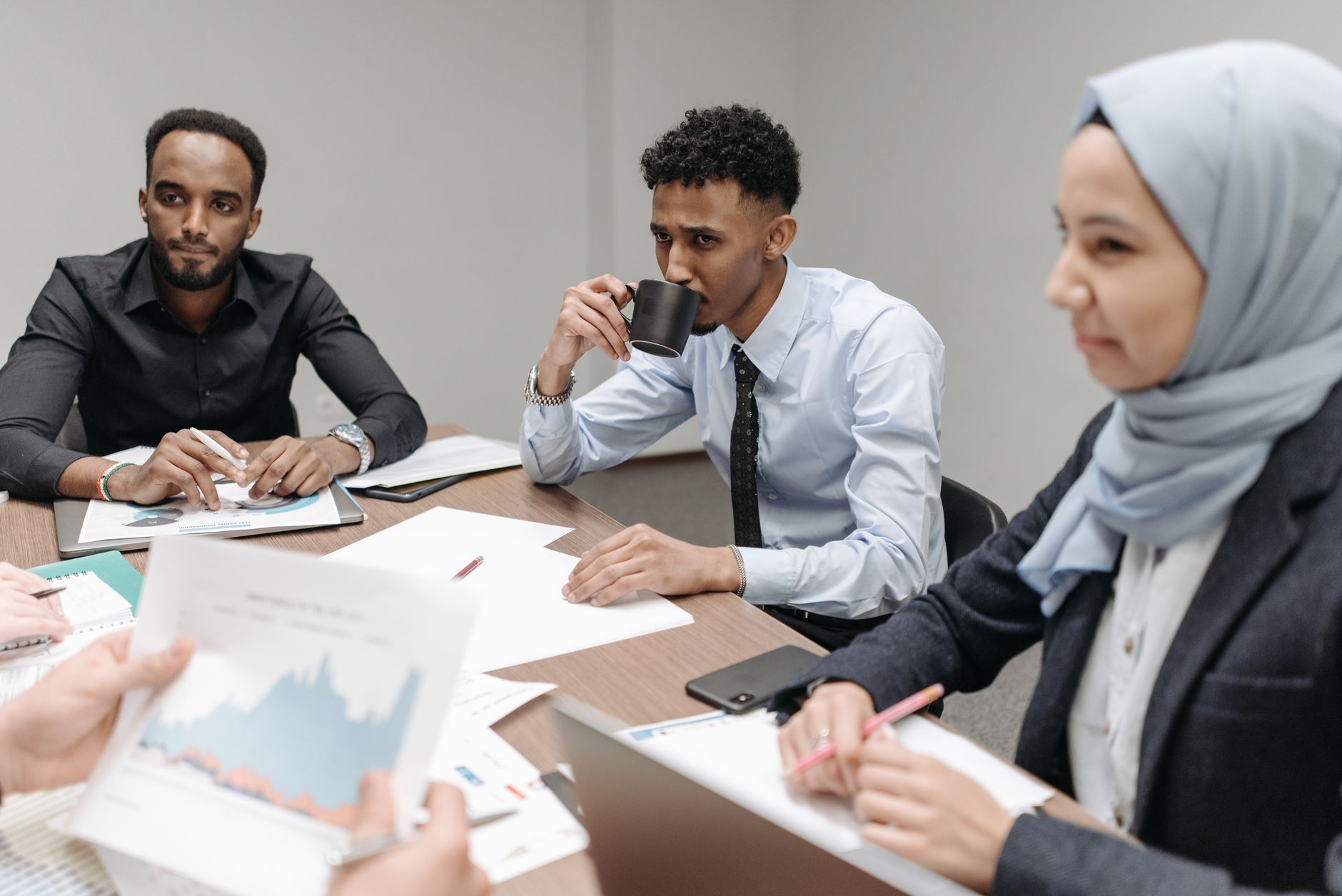 A multicultural team engaged in discussion during an office meeting, highlighting diversity and teamwork. — Leading Innovatio