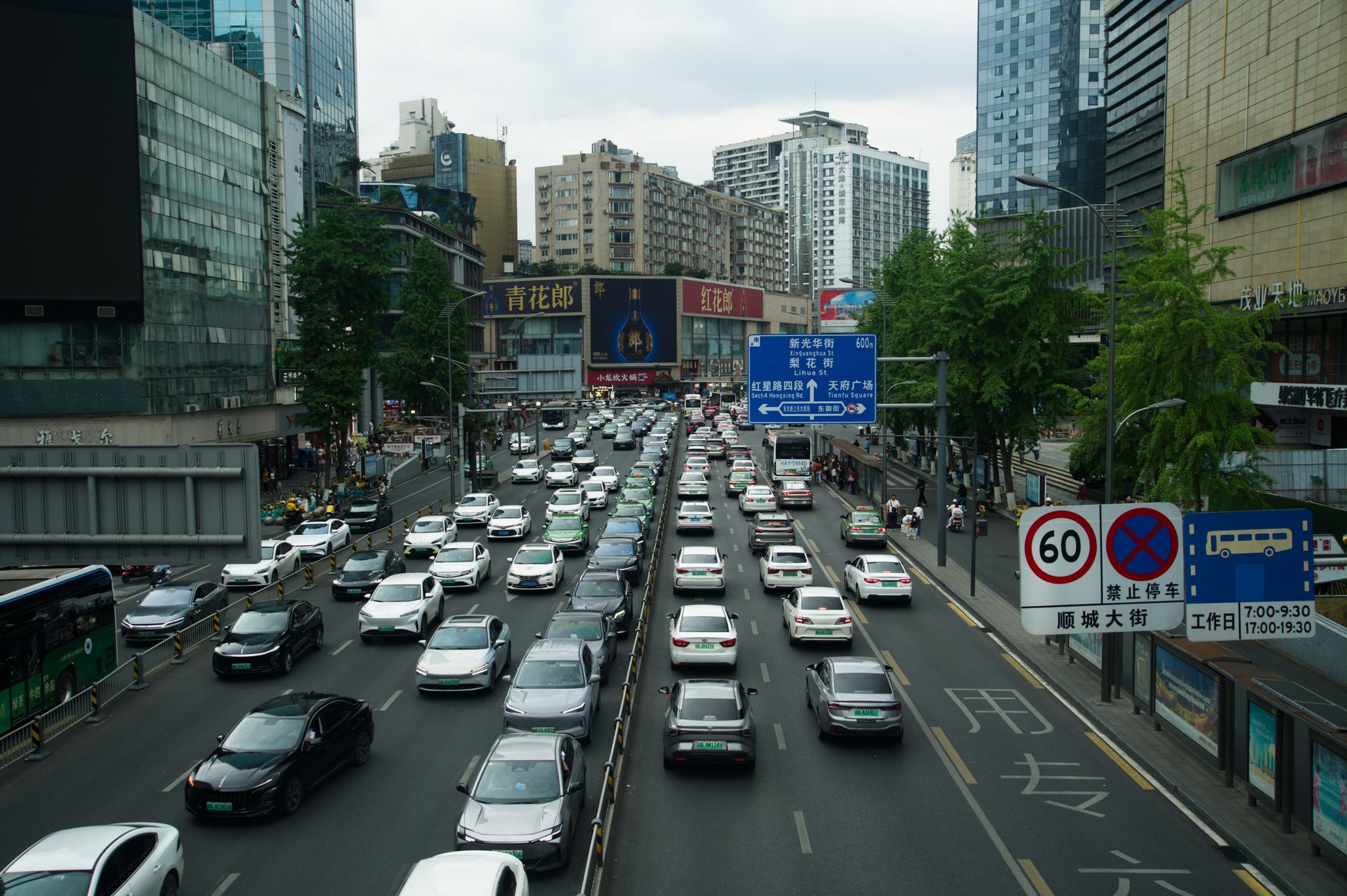Heavy traffic on a busy Shanghai street lined with skyscrapers and billboards during the day. — Little Pepe Presale: Redefini