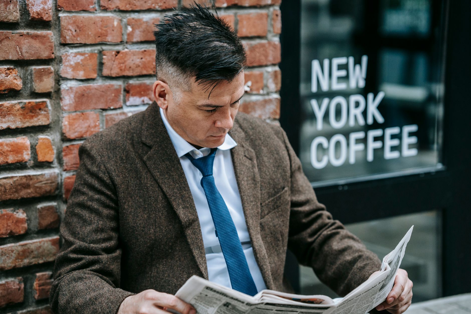 Man in formal attire reading a newspaper outside New York coffee shop. — Maintaining Healthy Brain Function: Improve Brain De