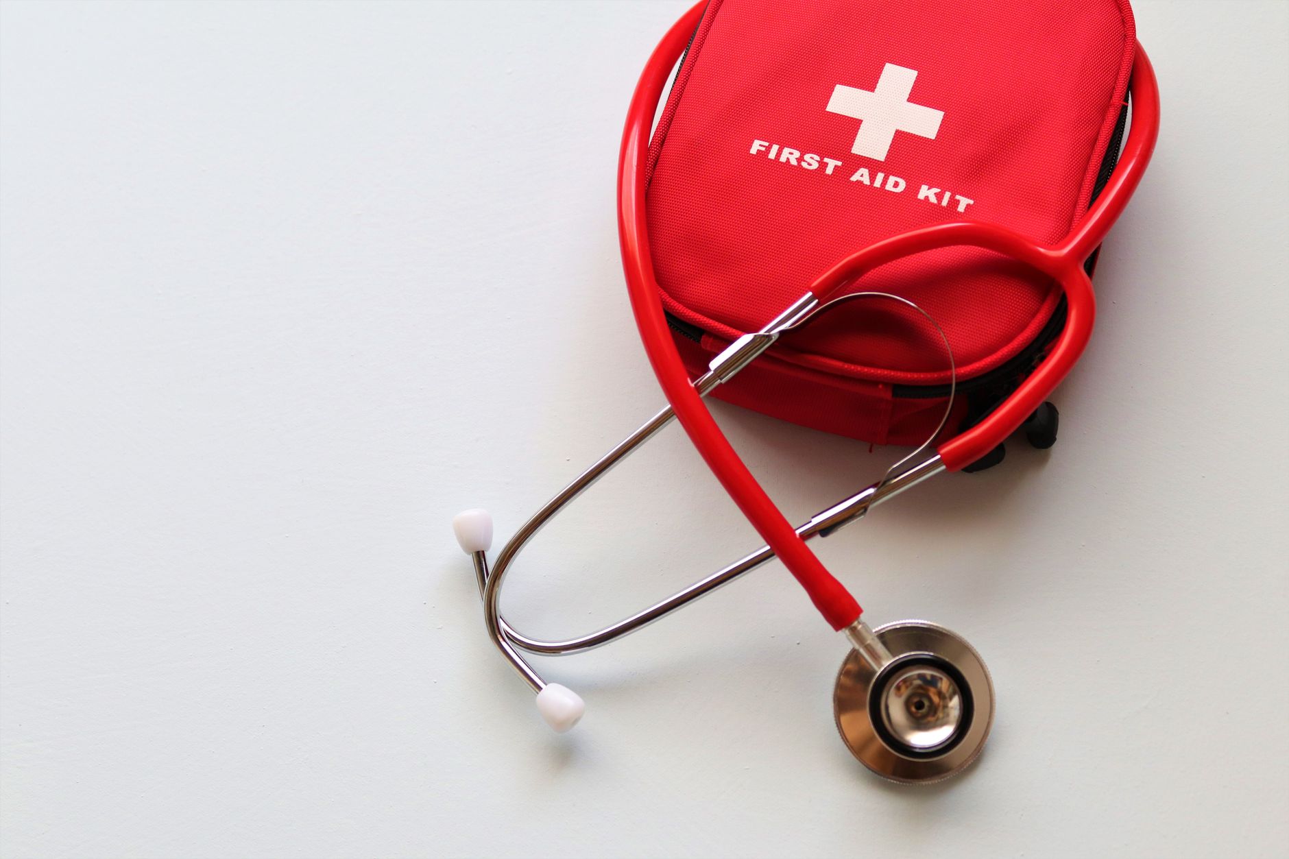 A red first aid kit paired with a stethoscope, signifying healthcare and medical treatment essentials. — Patient Access to Me
