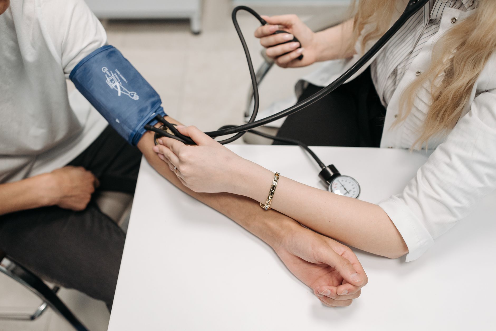 A doctor measures a patient's blood pressure with a sphygmomanometer during a consultation. — Personal Power and Living Your