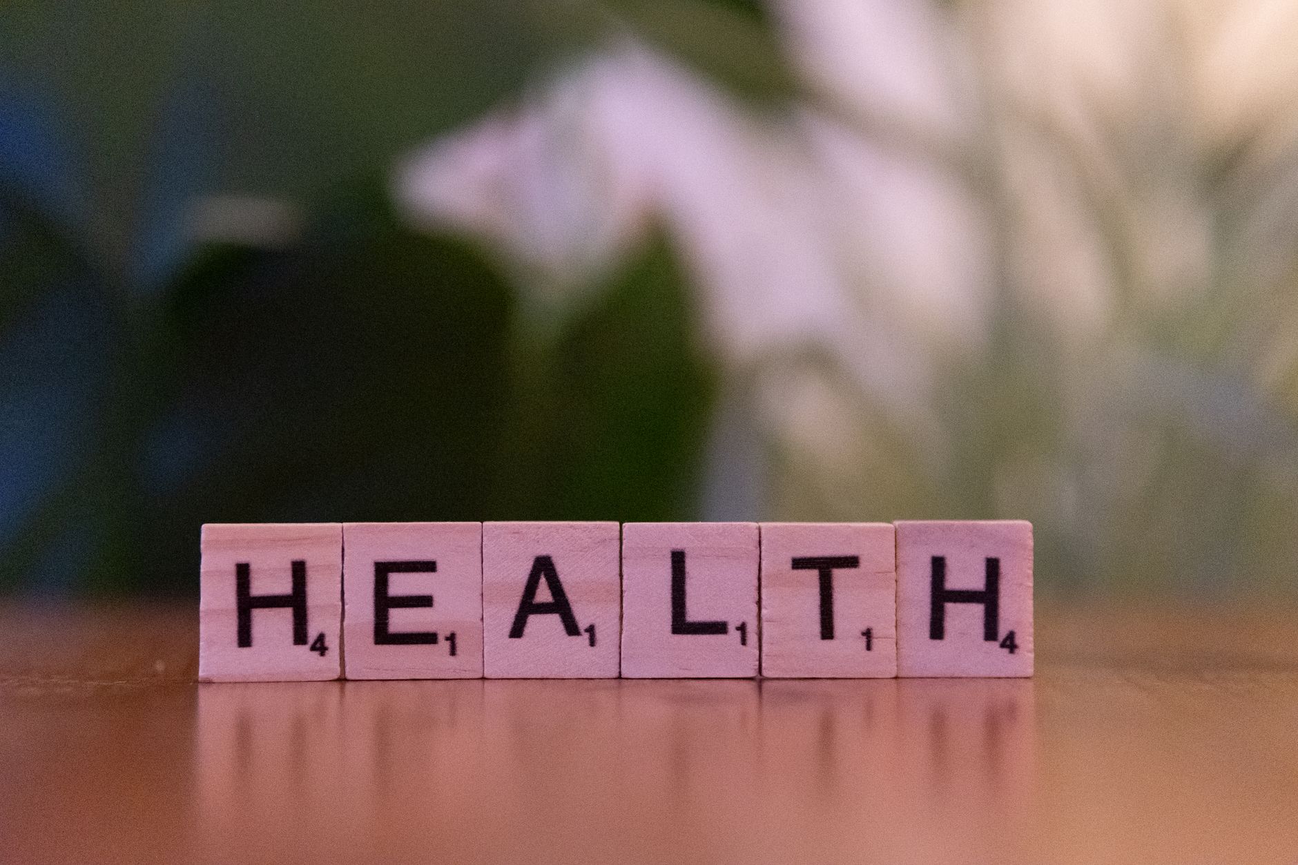 Close-up of Scrabble tiles spelling 'Health' on a wooden table with a blurred background. — The Final Deal About Biofreeze Ro