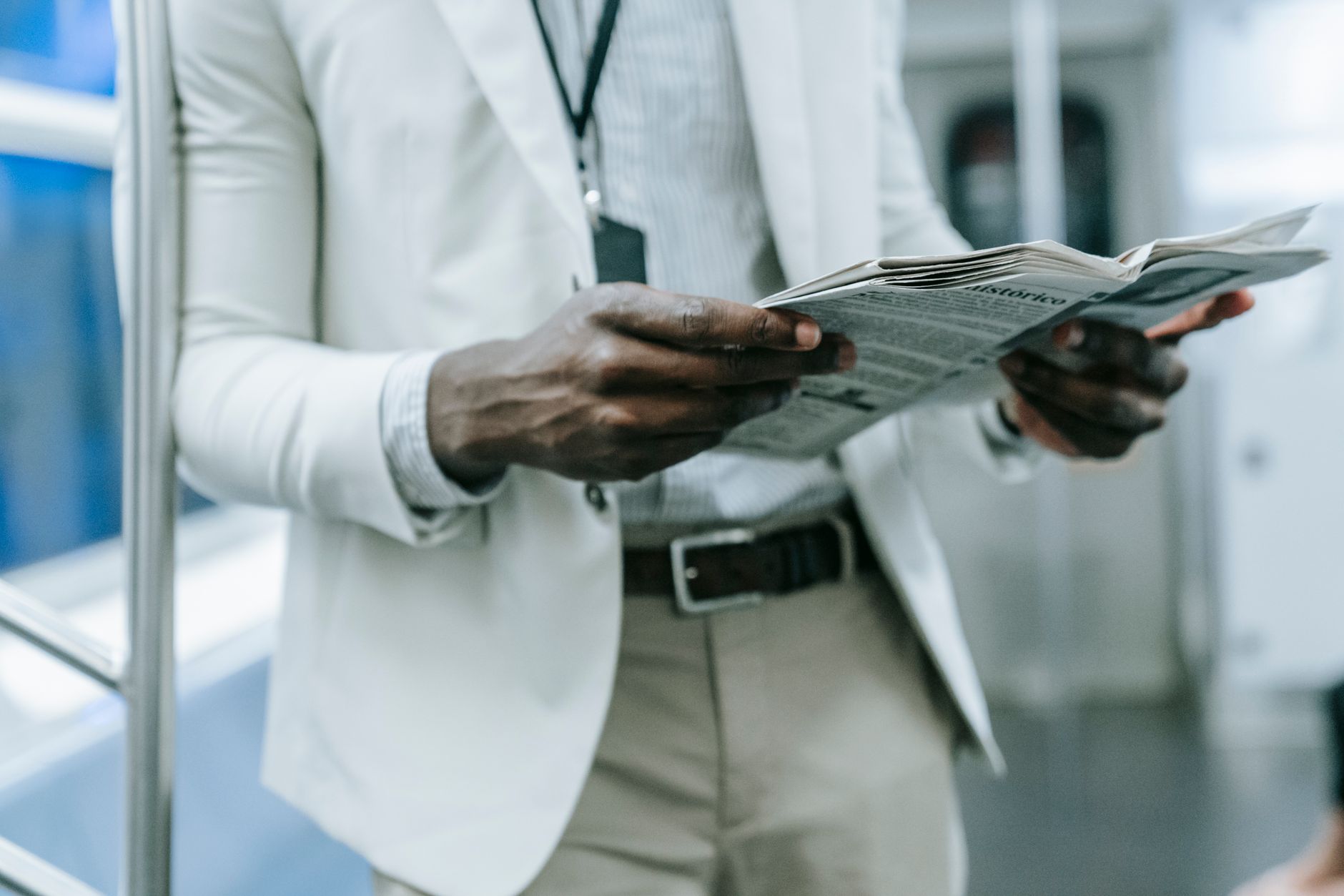 A professional in a blazer reads a newspaper while commuting on a train. — The five best medical books for prospective medica