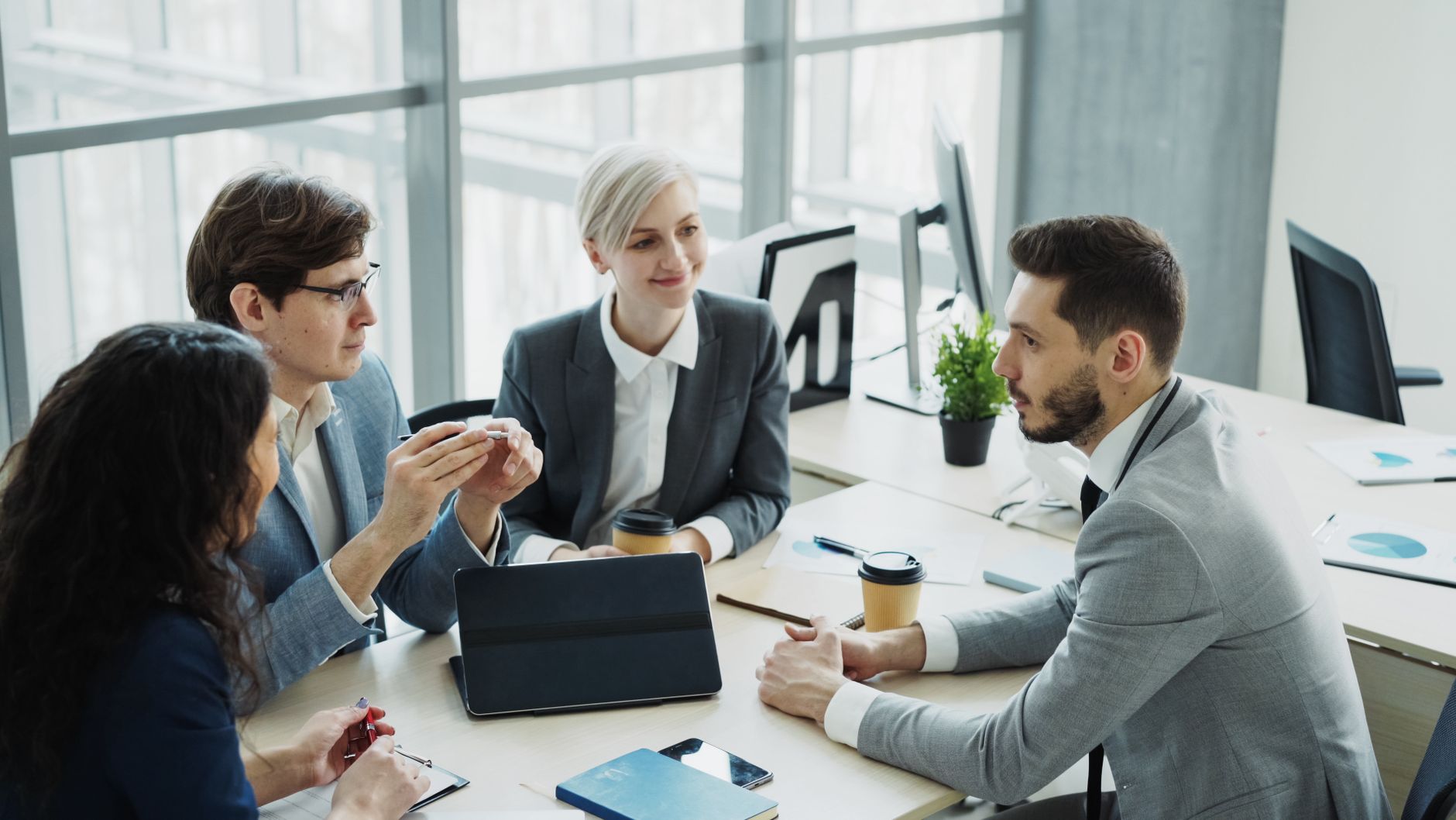 Group of professionals having a discussion in a modern office setting with natural light. — The Future of Intimacy: Tech-Driv