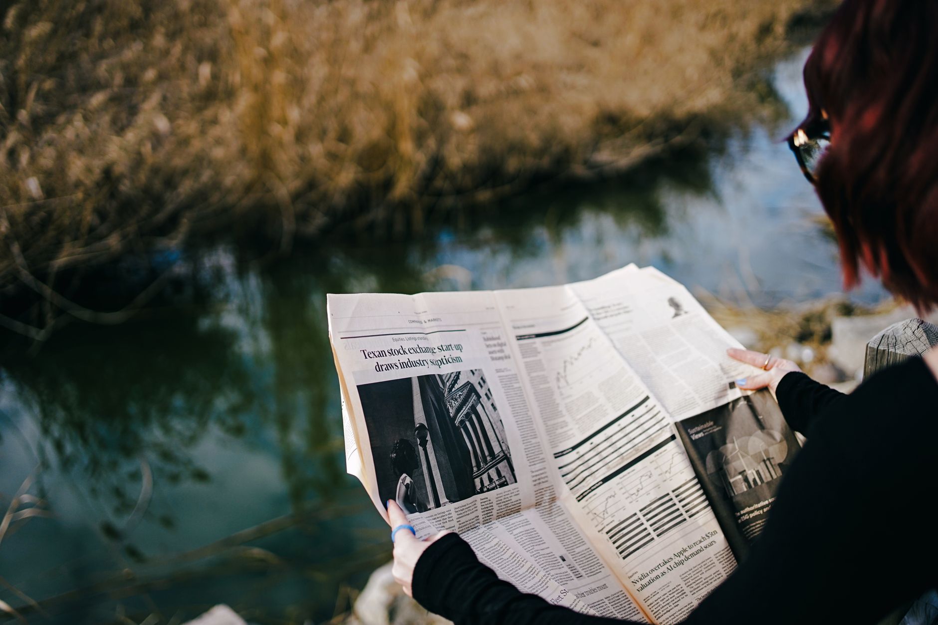 A person enjoys reading a newspaper by a tranquil pond on a sunny day. — Using a Weight Lifting Belt for Maximum Effect